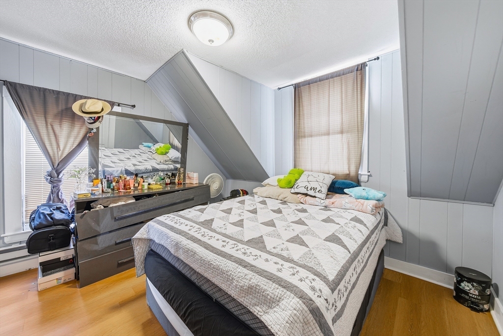 94 Sheridan Street Lynn, MA 01902 - Photo 24 of 33 a bedroom with a bed a dresser and potted plants on the table
