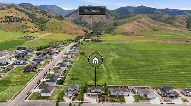 338 Windy Rdg Drive Smithfield, UT 84335 - Photo 61 of 63 Aerial perspective showcasing a residential street with properties, expansive green fields, and distant mountains