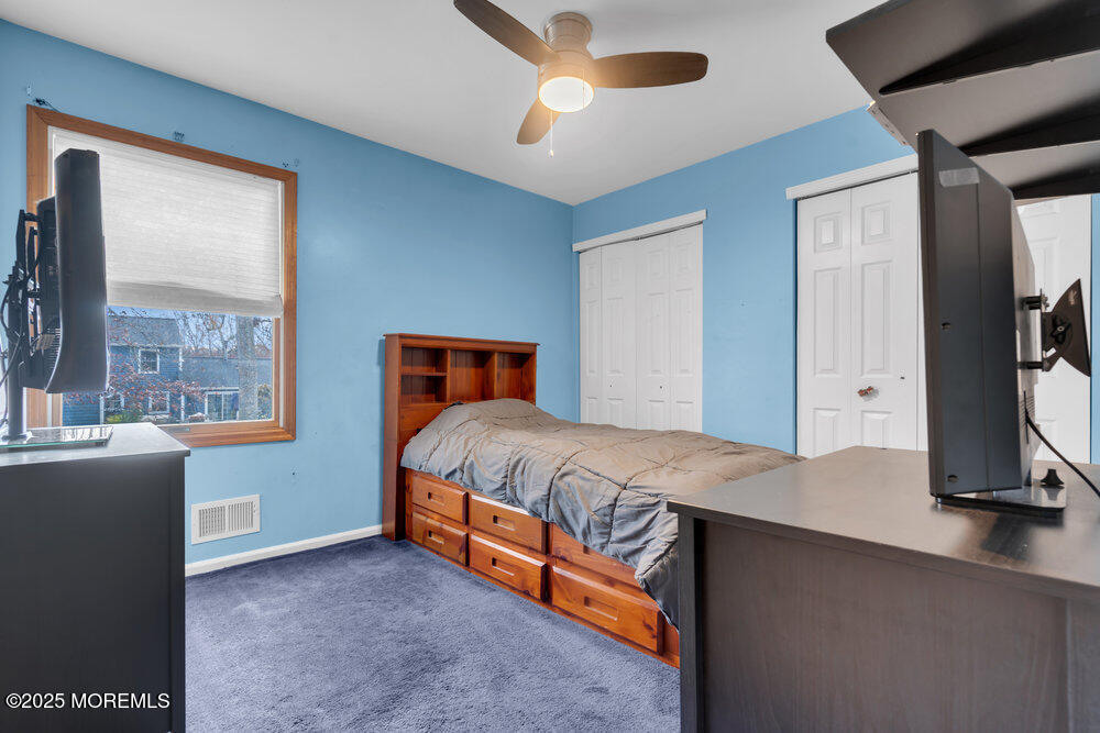 25 Concord Circle Howell, NJ 07731 - Photo 13 of 26 a bedroom with a bed and a flat tv screen on dresser