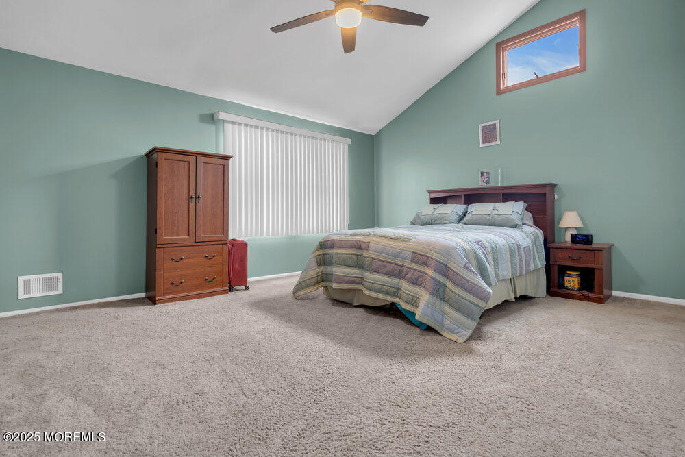 25 Concord Circle Howell, NJ 07731 - Photo 15 of 26 a bedroom with a bed and a chandelier