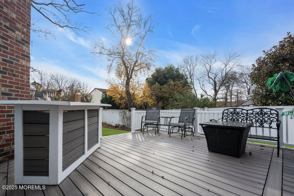 25 Concord Circle Howell, NJ 07731 - Photo 17 of 26 a view of a roof deck with table and chairs a barbeque with wooden floor and fence