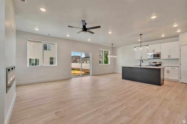 Open-concept living space featuring wood-finish flooring, recessed lighting, and a contemporary ceiling fan