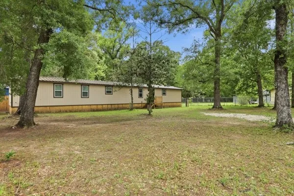 a front view of a house with a yard and trees