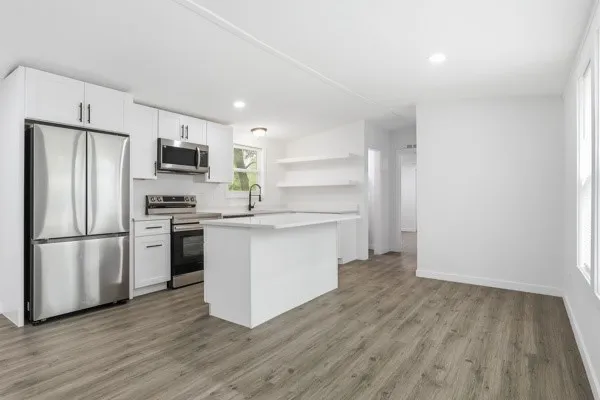 a kitchen with a refrigerator and a stove top oven