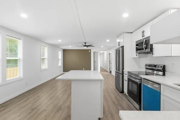 a kitchen with stainless steel appliances kitchen island granite countertop a stove a sink and a refrigerator