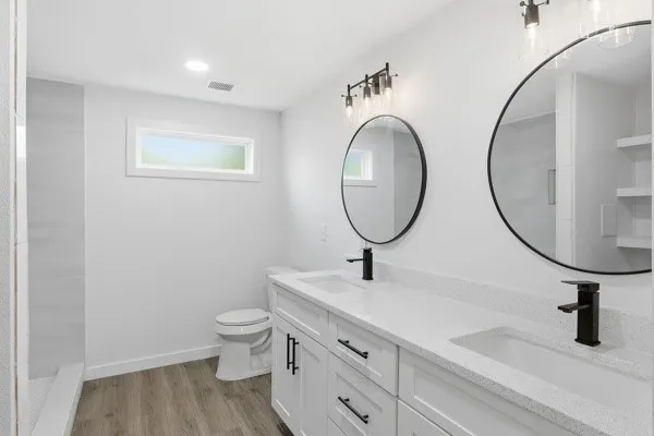 a bathroom with a toilet a sink and a mirror