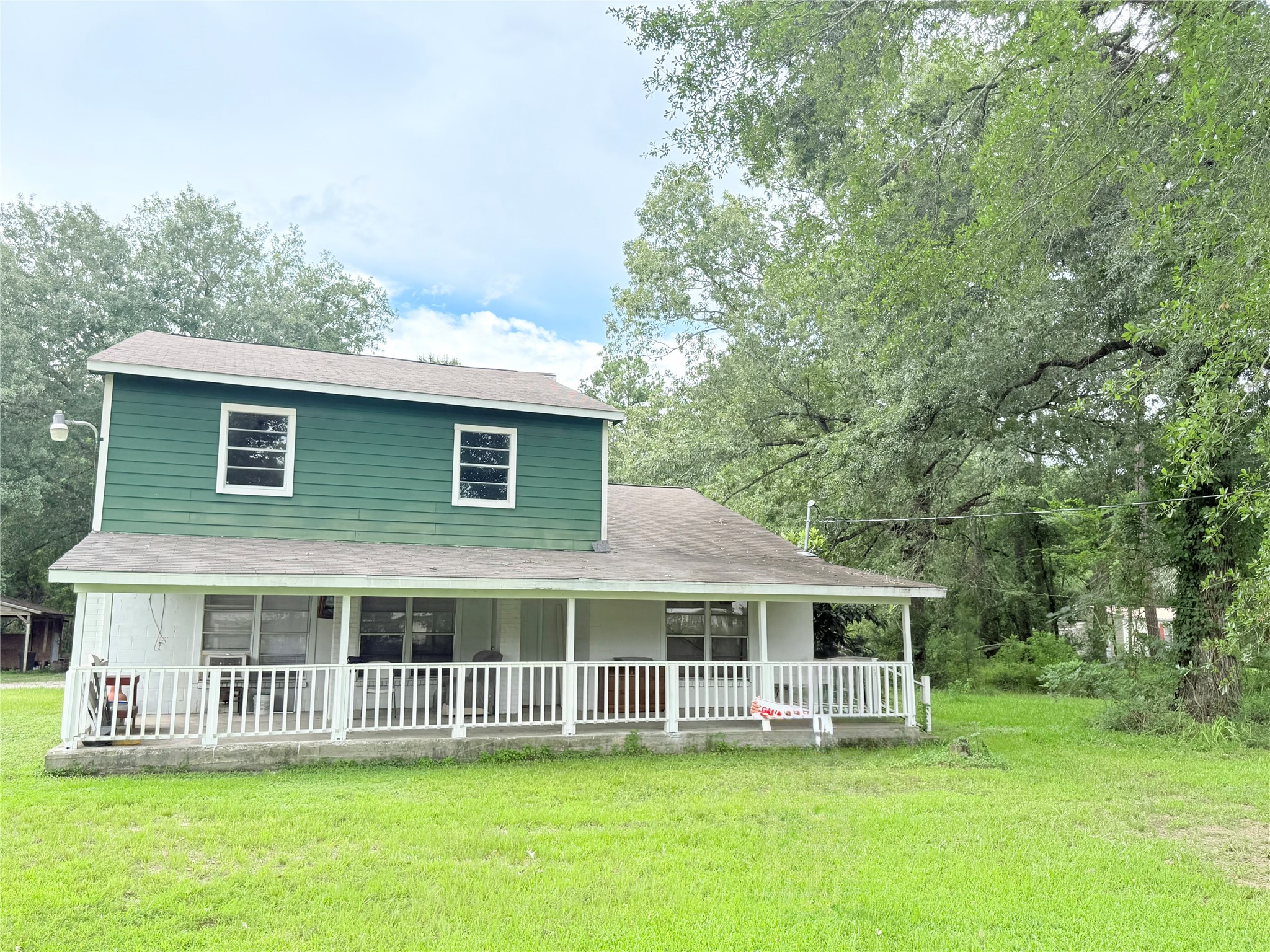 a view of a house with a big yard and large trees
