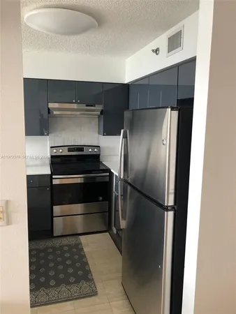 a kitchen with a refrigerator and a stove