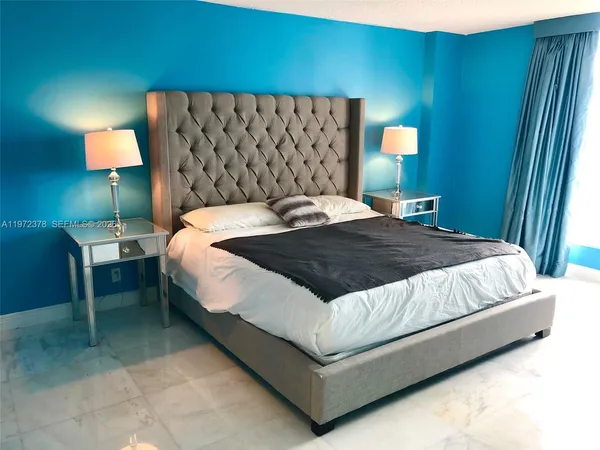 a bedroom with a bed lamp and a mirror