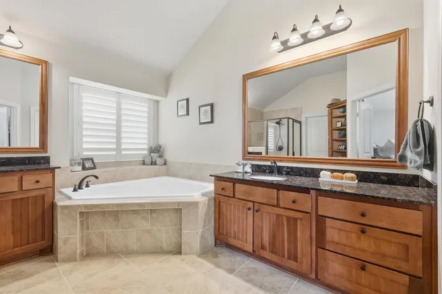 a spacious bathroom with a tub sink and mirror
