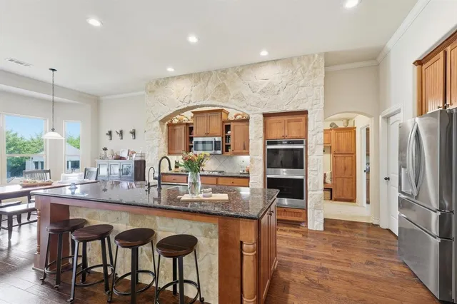 a kitchen with stainless steel appliances granite countertop a stove and a sink
