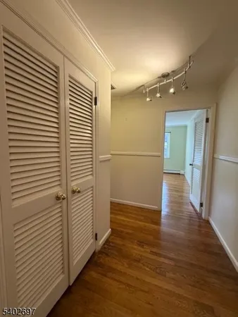 a view of empty room with wooden floor and window