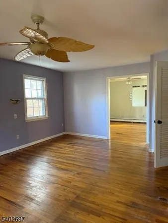 a view of a room with wooden floor and cabinets