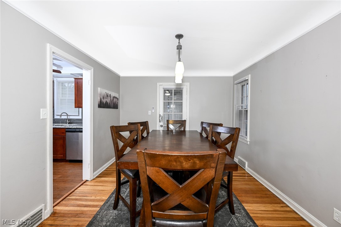 3699 Bainbridge Road Cleveland Heights, OH 44118 - Photo 9 of 37 Dining space with wood-finish flooring, two window exposures, and a contemporary ceiling light fixture