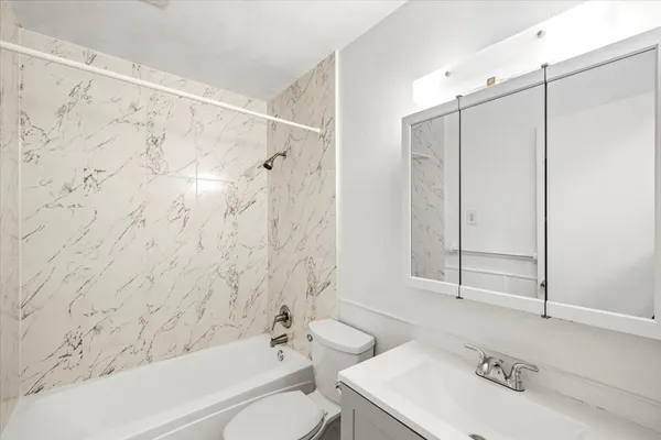 a bathroom with a sink a toilet and shower