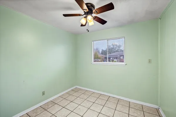 an empty room with a window and a fan