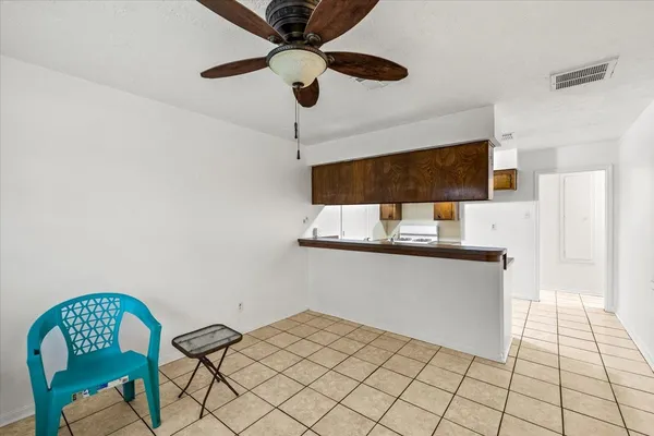 a kitchen with stainless steel appliances kitchen island granite countertop a white cabinets a dining table and chairs