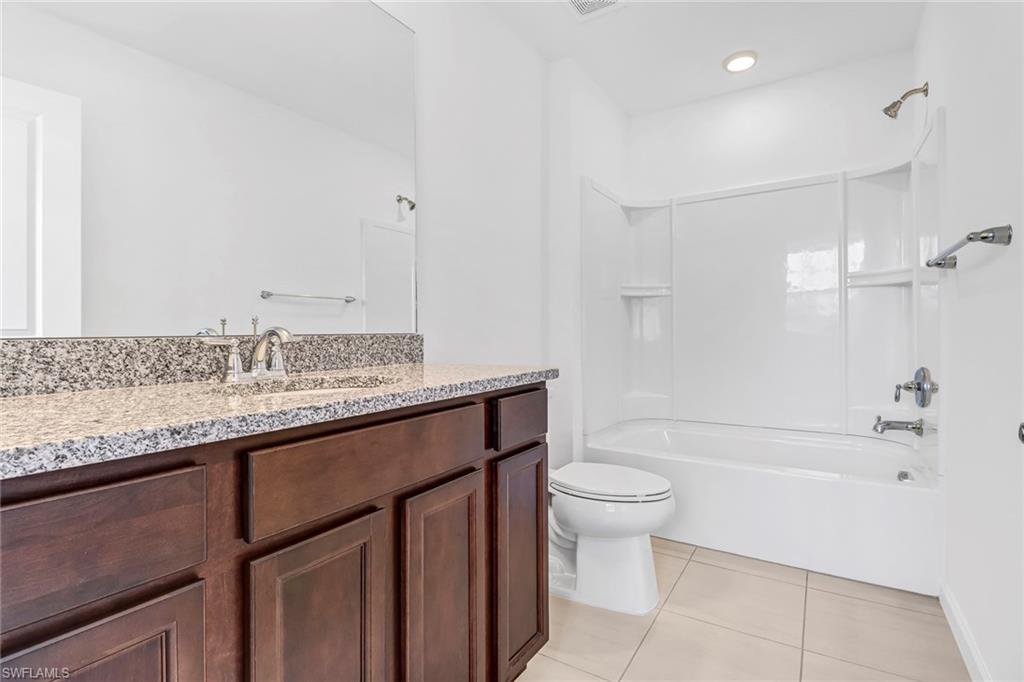 2167 Yellowfin Circle Naples, FL 34114 - Photo 20 of 36 a bathroom with a granite countertop sink a toilet and shower