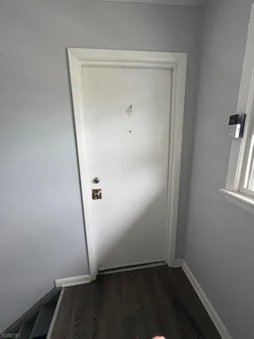 an empty room with wooden floor and white door