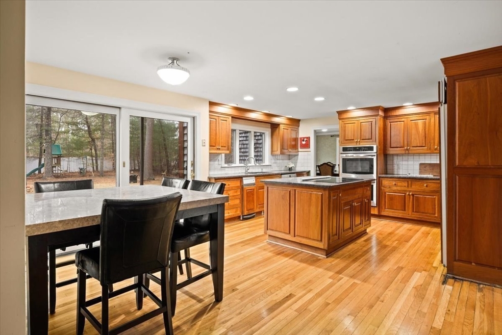 211 Cherry Street Bridgewater, MA 02324 - Photo 7 of 39 a kitchen with stainless steel appliances granite countertop wooden floor dining table and chairs