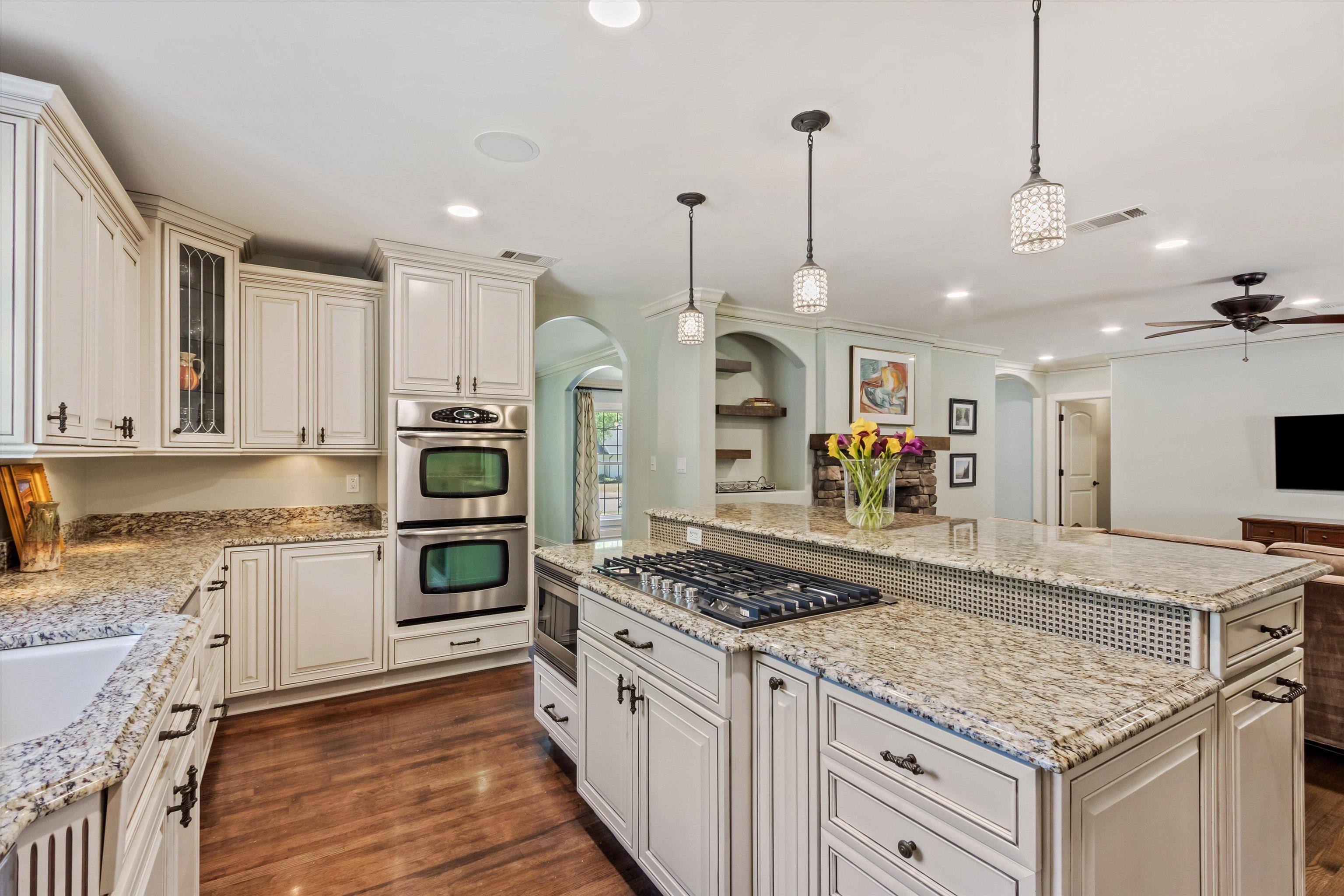 5302 South Angela Road Memphis, TN 38120 - Photo 13 of 40 Kitchen featuring light-toned cabinetry, granite countertops, double wall ovens, a gas cooktop, and wood-finish flooring
