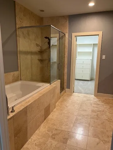 a bathroom with a tub a sink and a shower