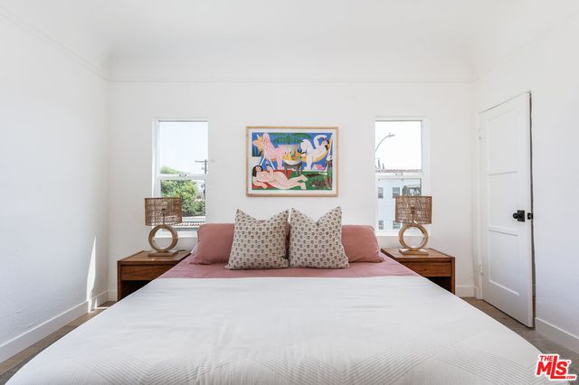 a bedroom with a large bed and a potted plant