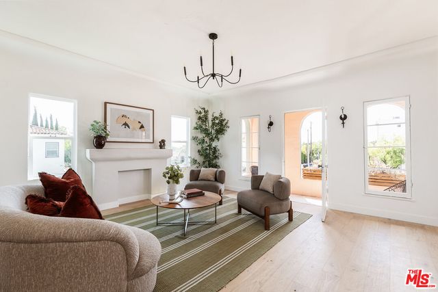a living room with furniture chandelier and a window