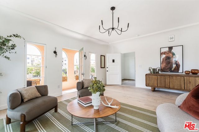 a living room with furniture a chandelier and a window