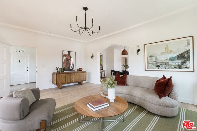 a living room with furniture a dining table a lamp and a chandelier