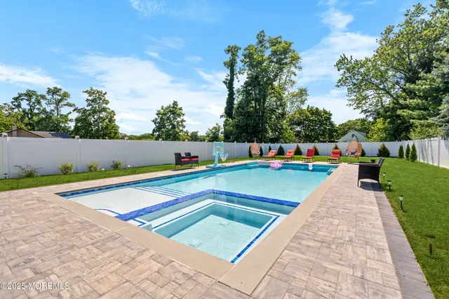 a view of swimming pool with a lounge chairs in front of main door