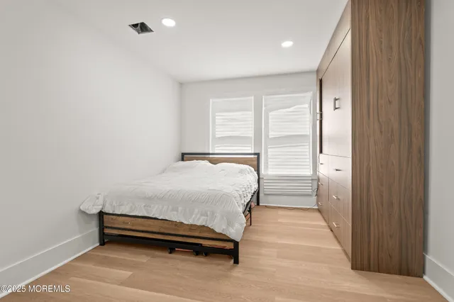 a spacious bedroom with a bed and a cabinet