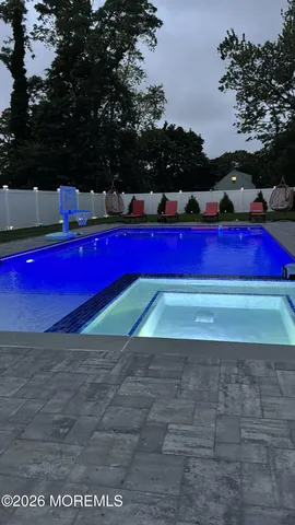 a view of swimming pool with red chairs