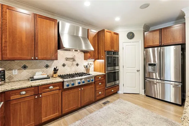 a kitchen with stainless steel appliances granite countertop a refrigerator stove and sink