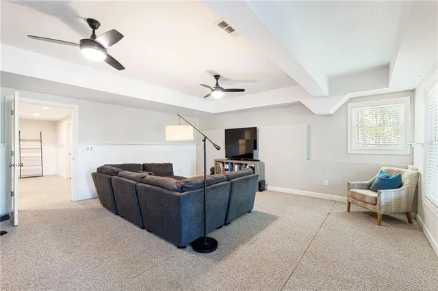 a living room with furniture and a ceiling fan