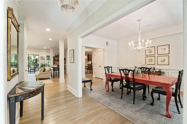 a view of a dining room and livingroom with furniture wooden floor a chandelier