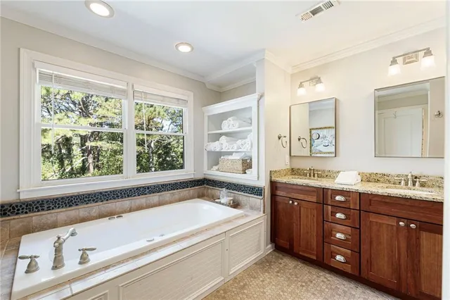 a spacious bathroom with a granite countertop tub sink and mirror