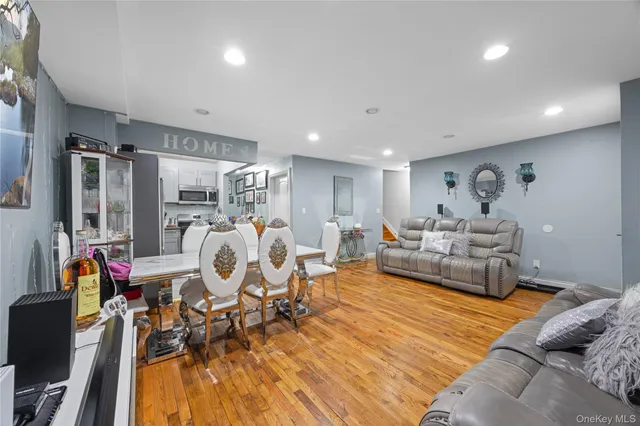 a living room with furniture a clock and a flat screen tv