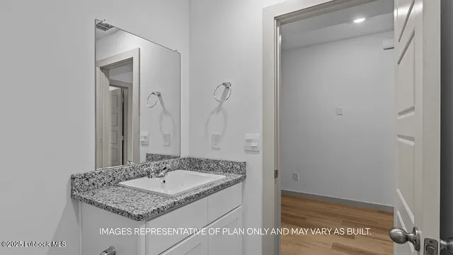 a bathroom with a granite countertop sink and a mirror