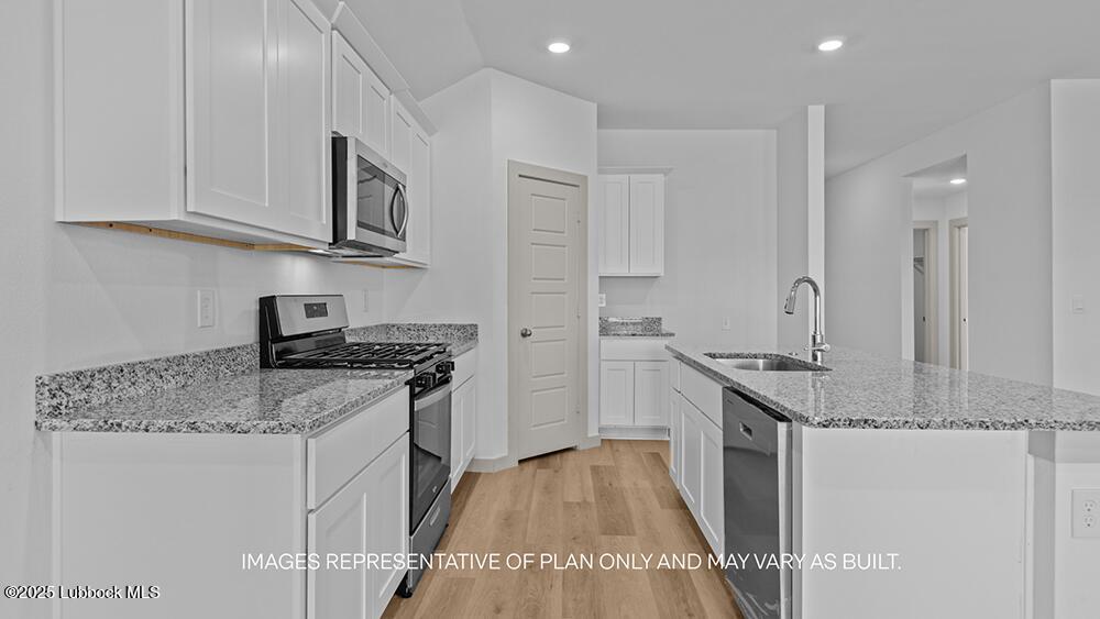 7429 9th Street Lubbock, TX 79416 - Photo 2 of 16 a kitchen with stainless steel appliances granite countertop a stove and a sink