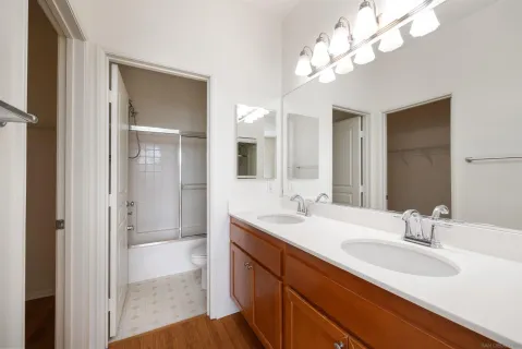 a bathroom with double vanity sinks a vanity a lamp and a mirror