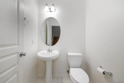 a bathroom with a toilet sink and mirror