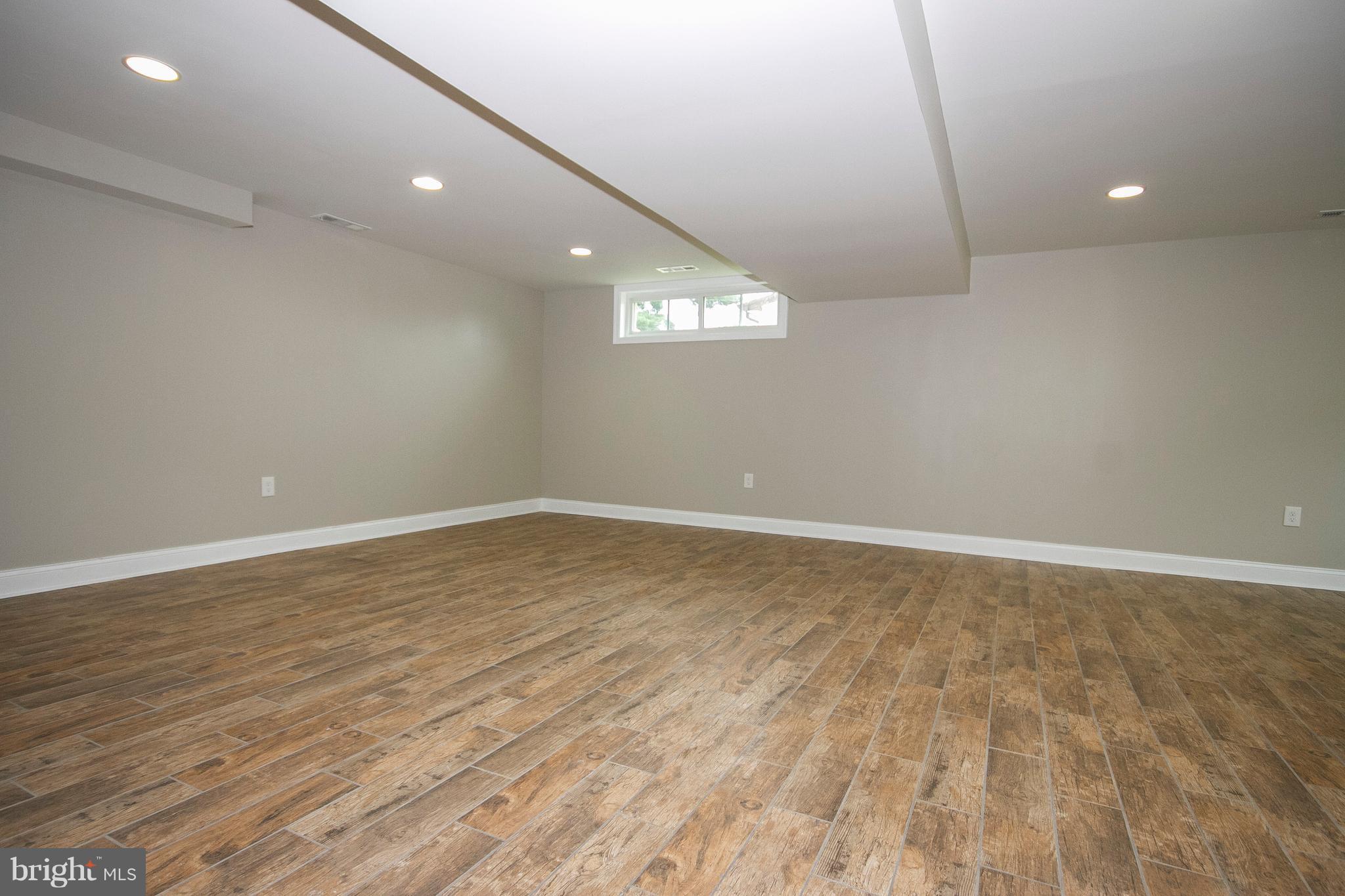 7412 Prince George Road Baltimore, MD 21208 - Photo 12 of 22 an empty room with wooden floor and windows