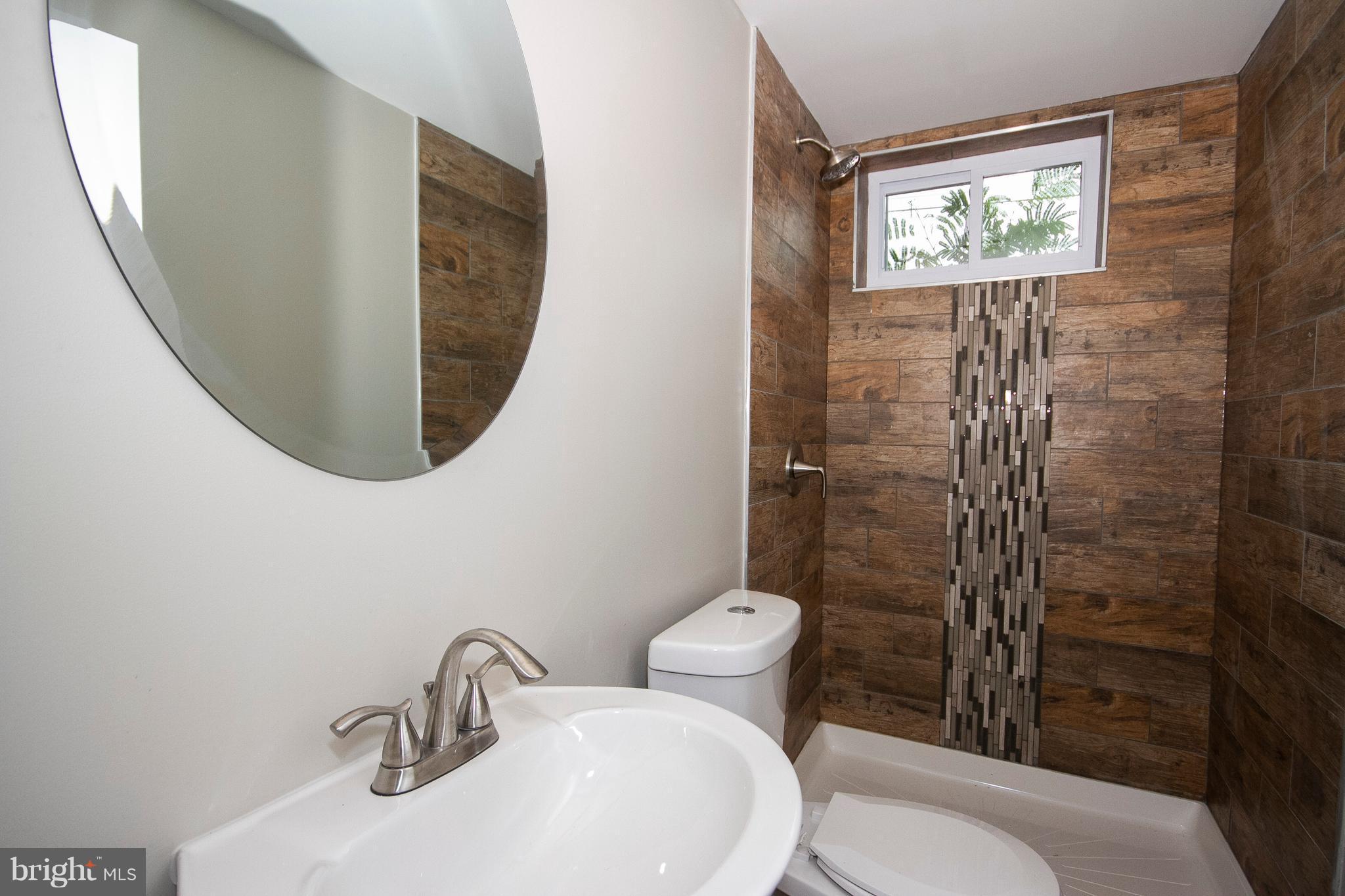 7412 Prince George Road Baltimore, MD 21208 - Photo 16 of 22 a bathroom with a mirror sink and toilet
