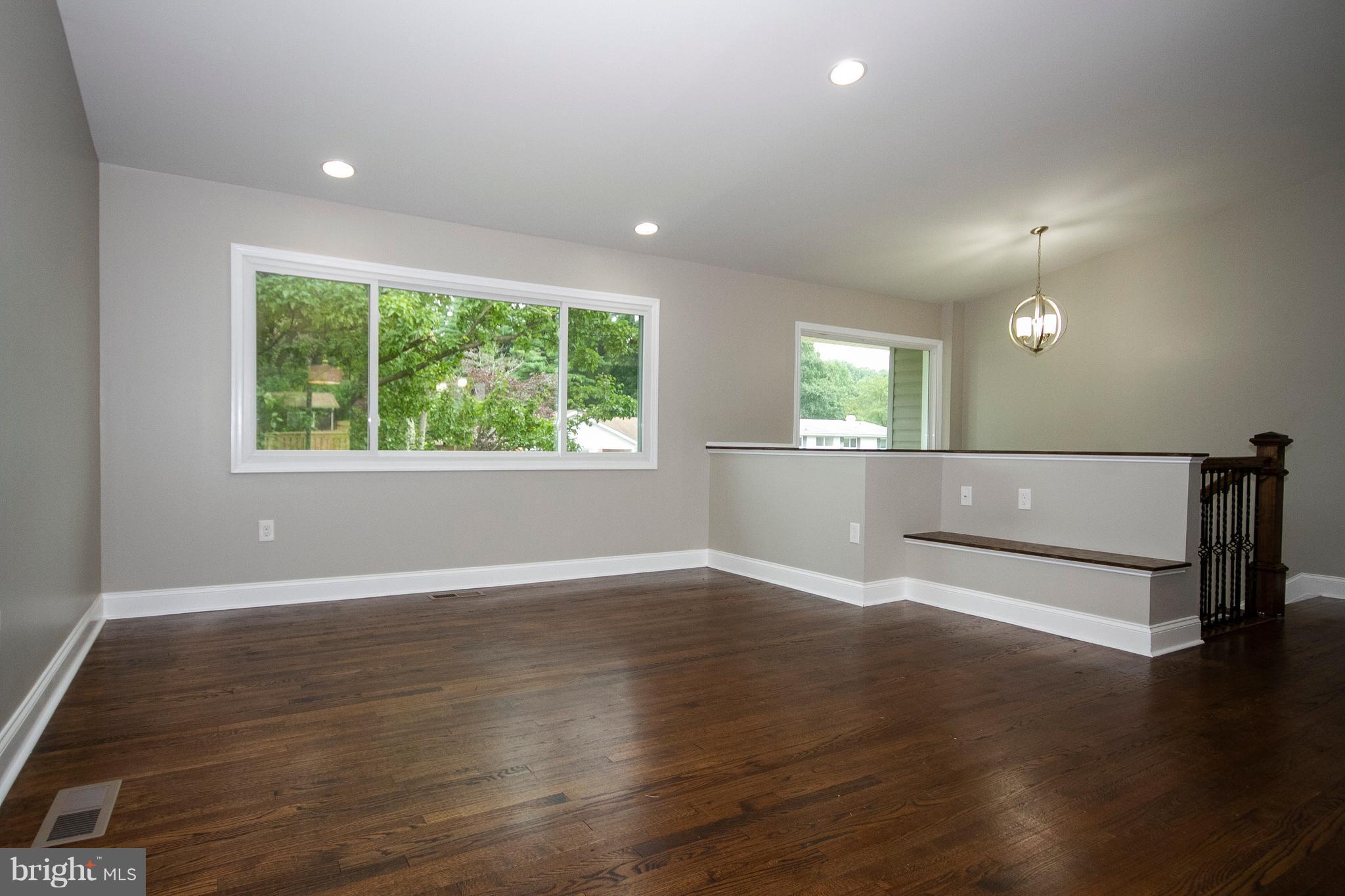 7412 Prince George Road Baltimore, MD 21208 - Photo 3 of 22 an empty room with wooden floor and windows