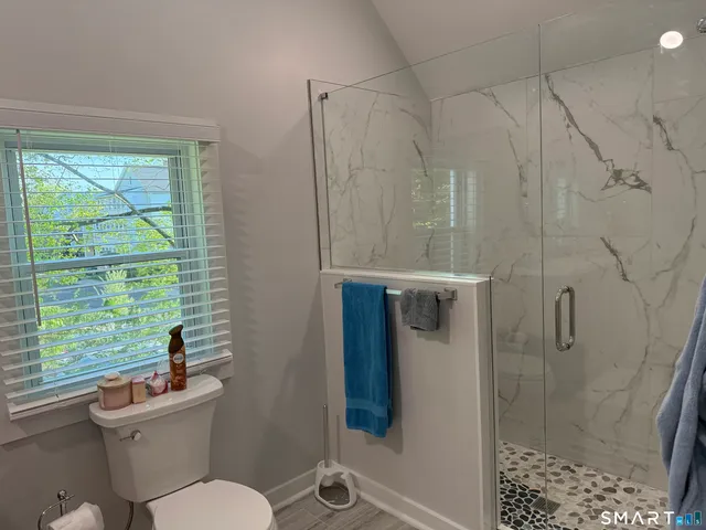 a bathroom with a toilet a sink and shower