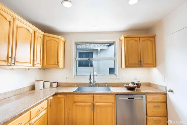 a kitchen with granite countertop a stove a sink and a window
