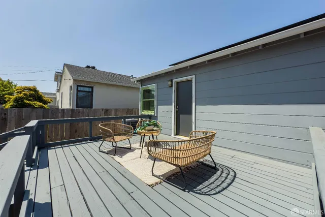 a view of a roof deck with couches chairs and wooden floor