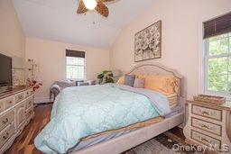 63 East Tiana Road Hampton Bays, NY 11946 - Photo 19 of 30 a bedroom with a large bed and a flat tv screen on dresser