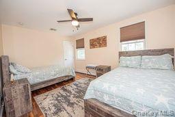 63 East Tiana Road Hampton Bays, NY 11946 - Photo 21 of 30 a bedroom with a bed and ceiling fan